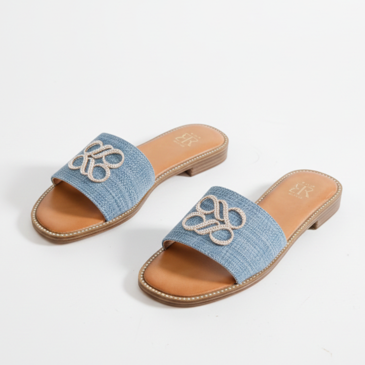 Mules plates en jean bleu avec un détail décoratif
