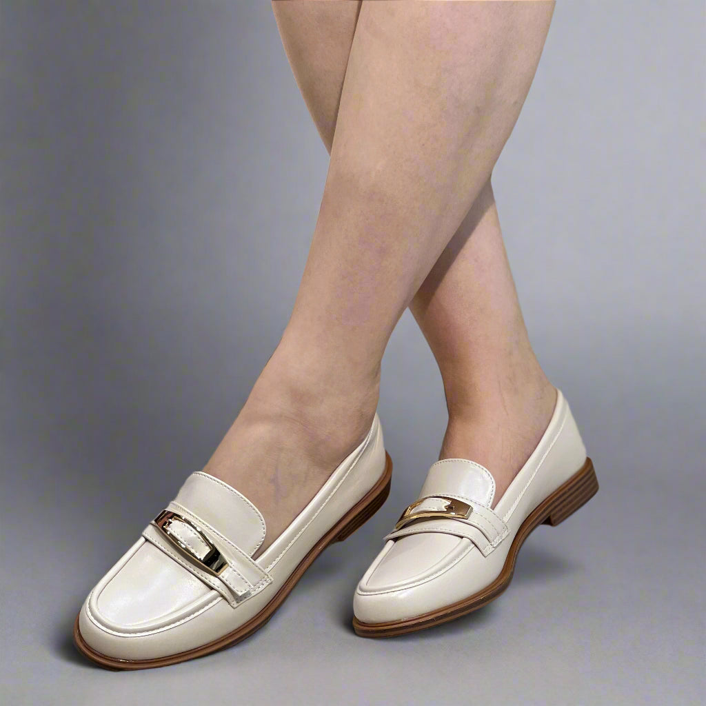 Mocassins classiques à bride métallique finition lisse et semelle plate.