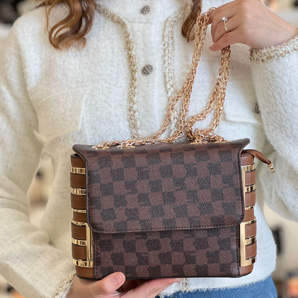 Sac à main présente des détails dorés et une bandoulière chaîne